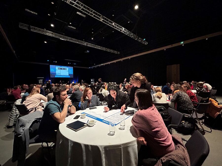 Large consultation room with dozens of participants